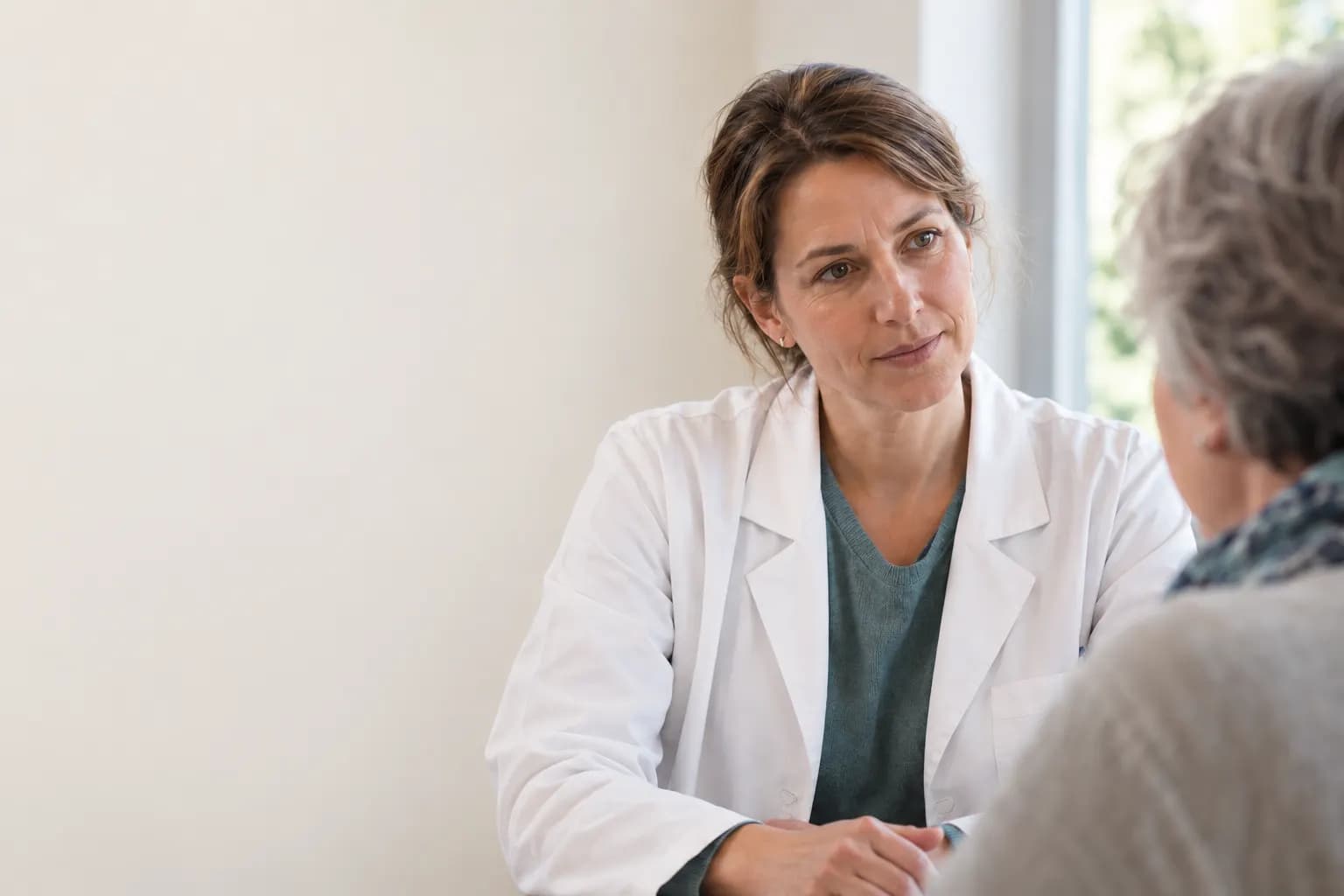 AI-generated image: a physician in a white coat listens to a patient in the consulting room.